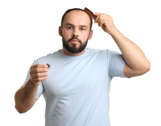 Photo of Baldness problem. Man with comb and clump of lost hair on white background
