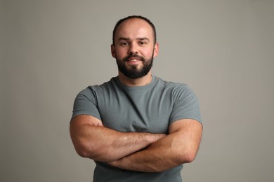 Photo of Baldness problem. Portrait of smiling man with receding hairline on grey background