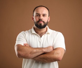 Photo of Baldness problem. Portrait of man with receding hairline on brown background