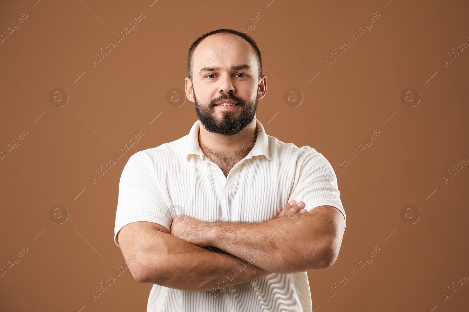 Photo of Baldness problem. Portrait of smiling man with receding hairline on brown background