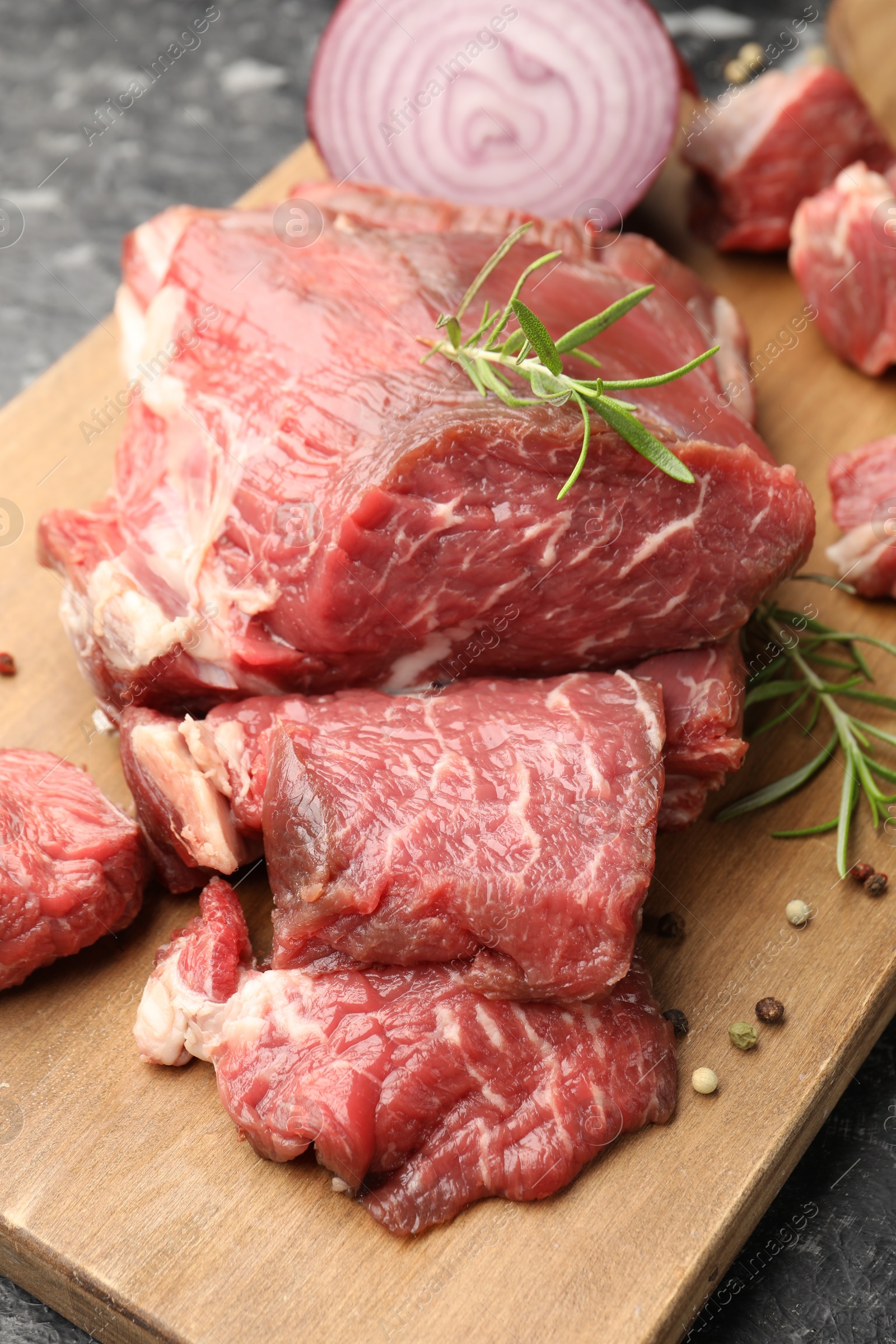 Photo of Pieces of raw beef meat and spices on table, closeup