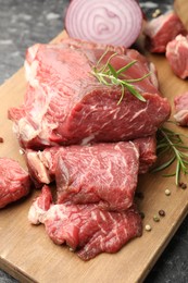 Photo of Pieces of raw beef meat and spices on table, closeup