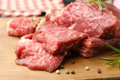 Photo of Pieces of raw beef meat and spices on table, closeup