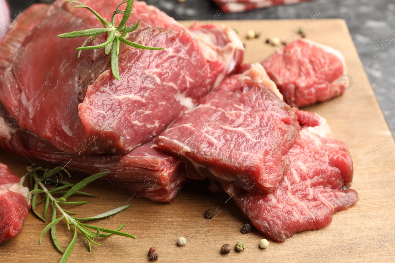 Photo of Pieces of raw beef meat and spices on table, closeup