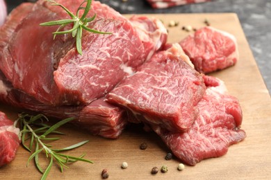 Photo of Pieces of raw beef meat and spices on table, closeup