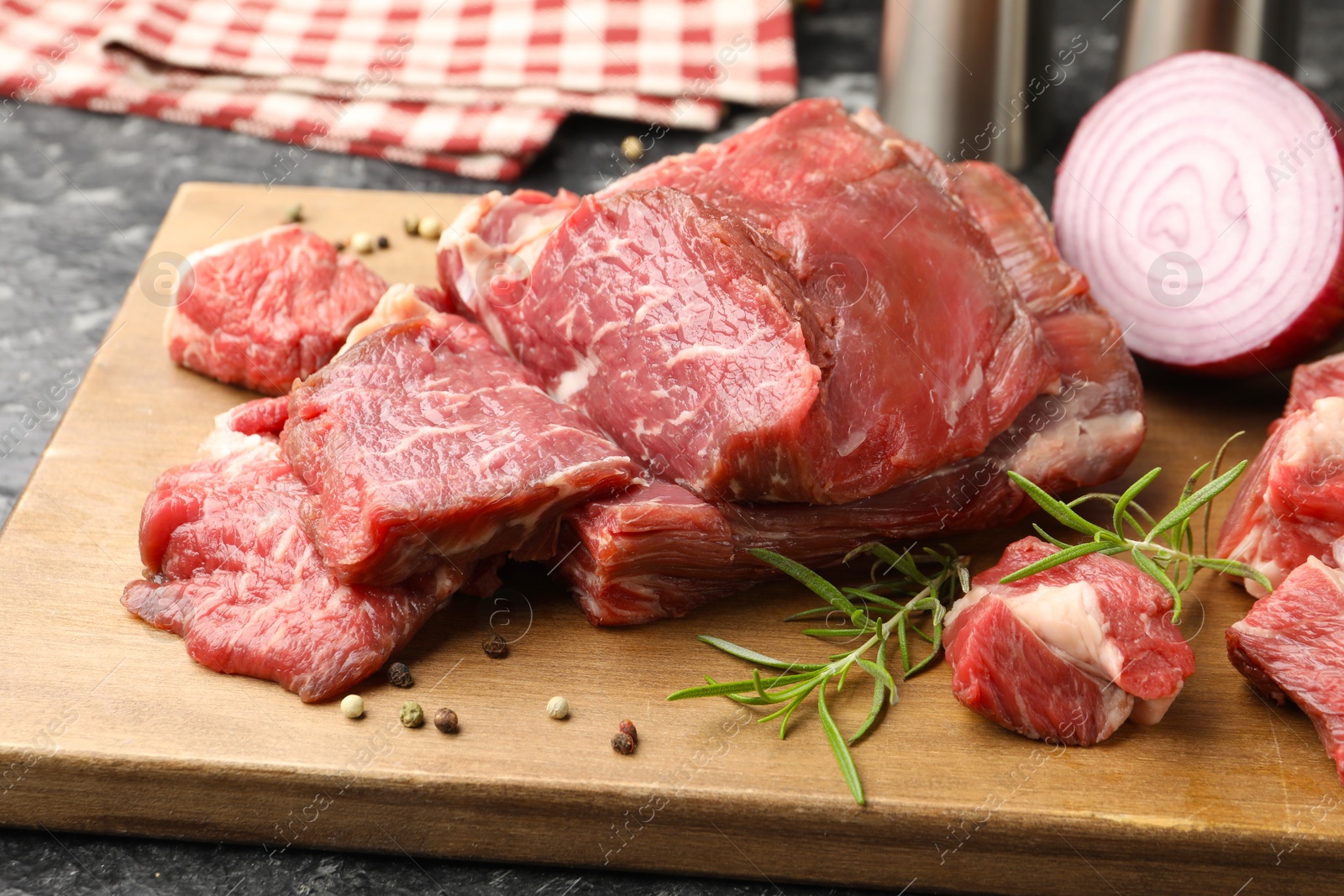 Photo of Pieces of raw beef meat and spices on table, closeup