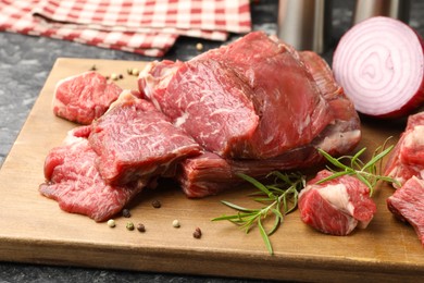 Photo of Pieces of raw beef meat and spices on table, closeup