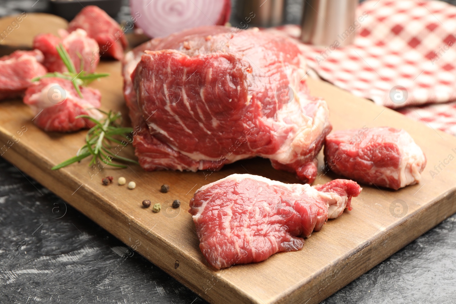 Pieces of raw beef meat and spices on black marble table, closeup Photo of Pieces of raw beef meat and spices on black marble table, closeup