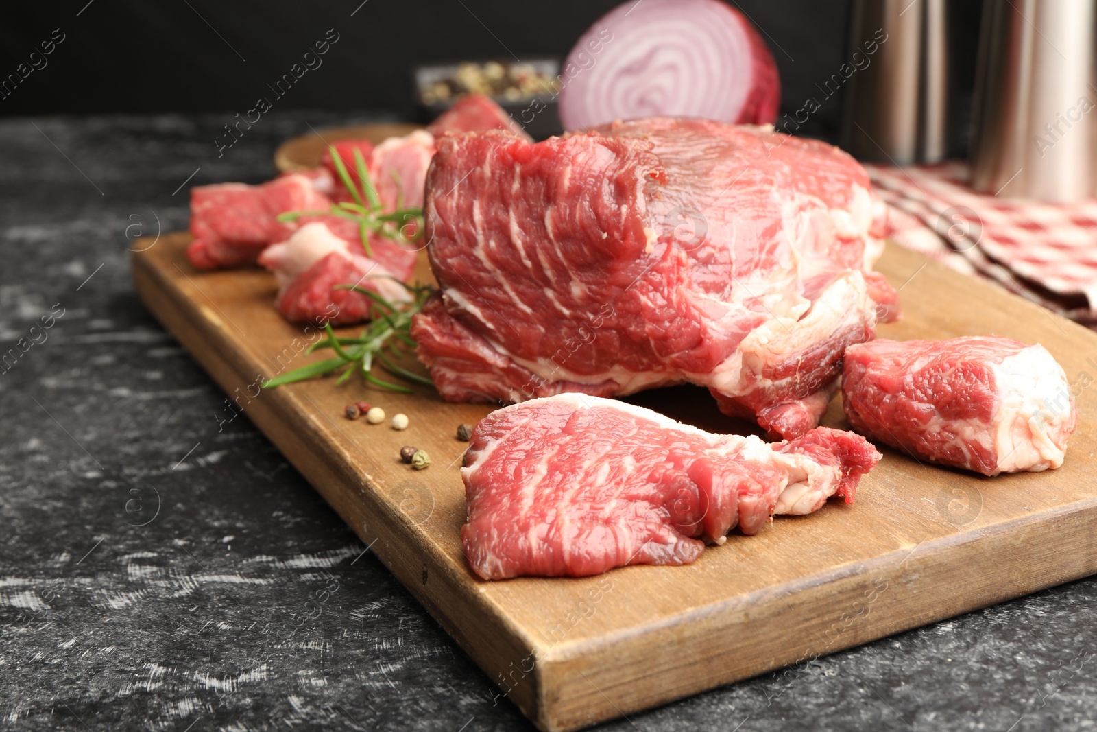 Pieces of raw beef meat and spices on black marble table, closeup Photo of Pieces of raw beef meat and spices on black marble table, closeup