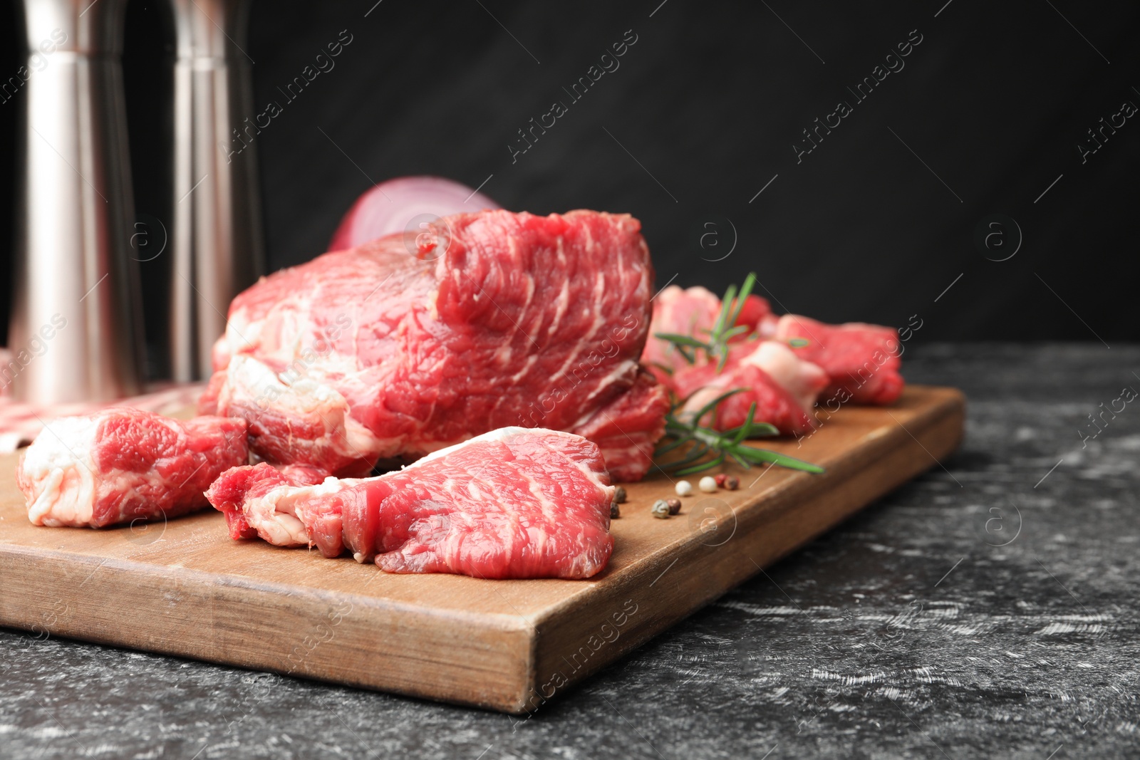 Pieces of raw beef meat and spices on black marble table, closeup Photo of Pieces of raw beef meat and spices on black marble table, closeup