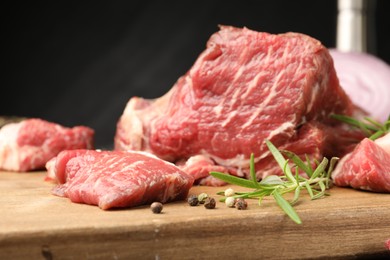 Photo of Pieces of raw beef meat and spices on table, closeup