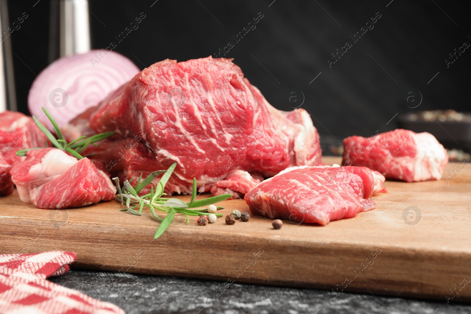 Pieces of raw beef meat and spices on black marble table, closeup Photo of Pieces of raw beef meat and spices on black marble table, closeup