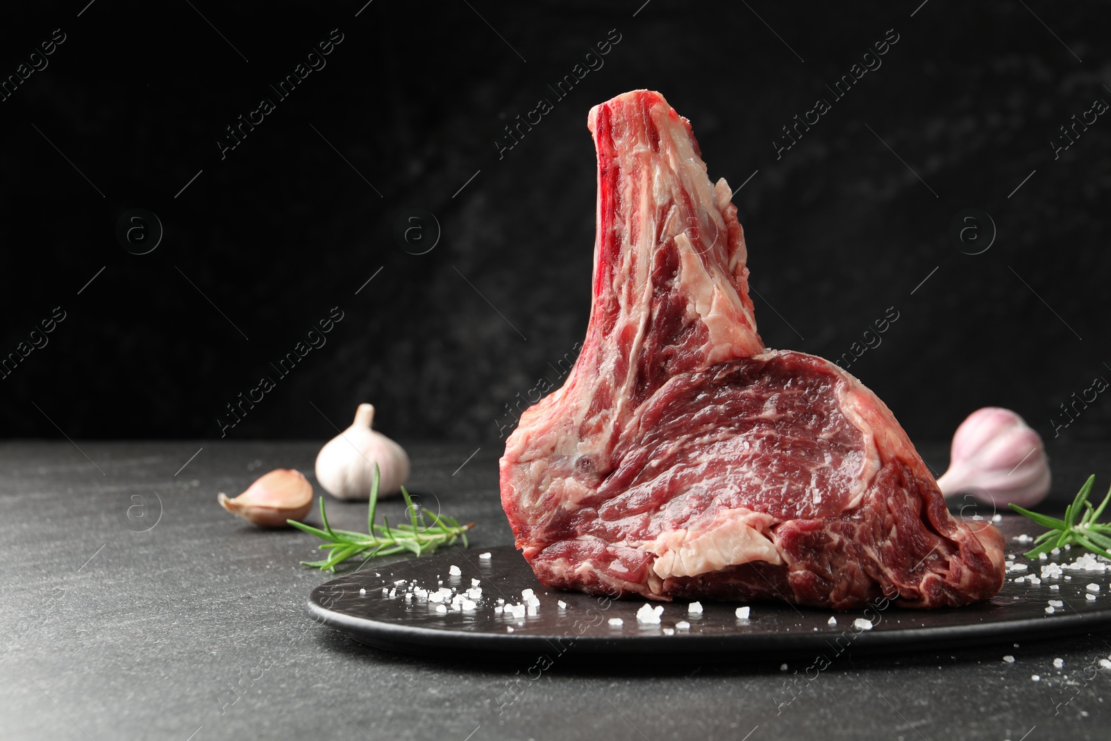 Piece of raw beef meat and spices on black table, closeup. Space for text Photo of Piece of raw beef meat and spices on black table, closeup. Space for text