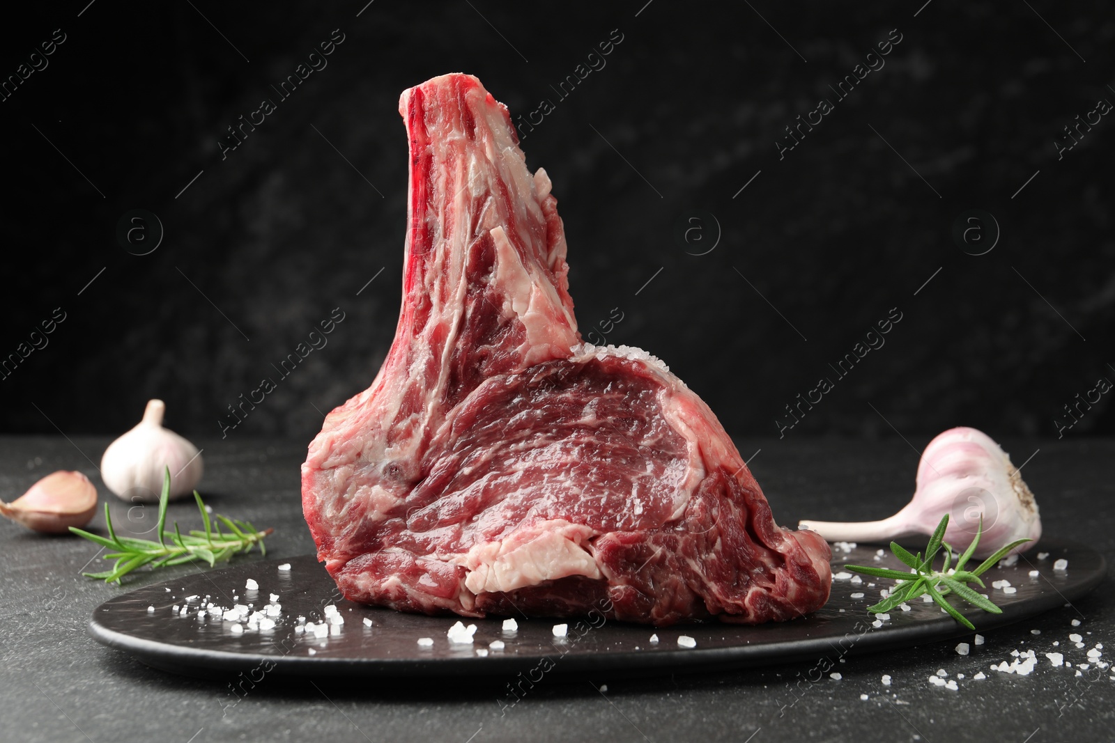 Piece of raw beef meat and spices on black table, closeup Photo of Piece of raw beef meat and spices on black table, closeup