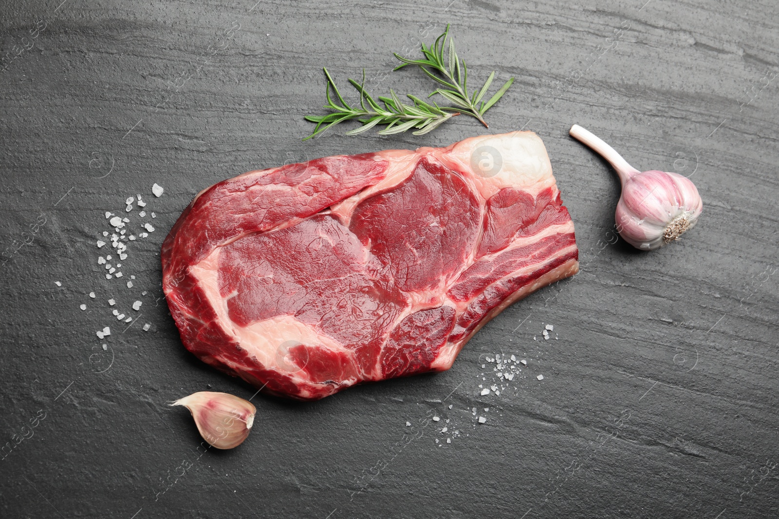Piece of raw beef meat and spices on black table, flat lay Photo of Piece of raw beef meat and spices on black table, flat lay