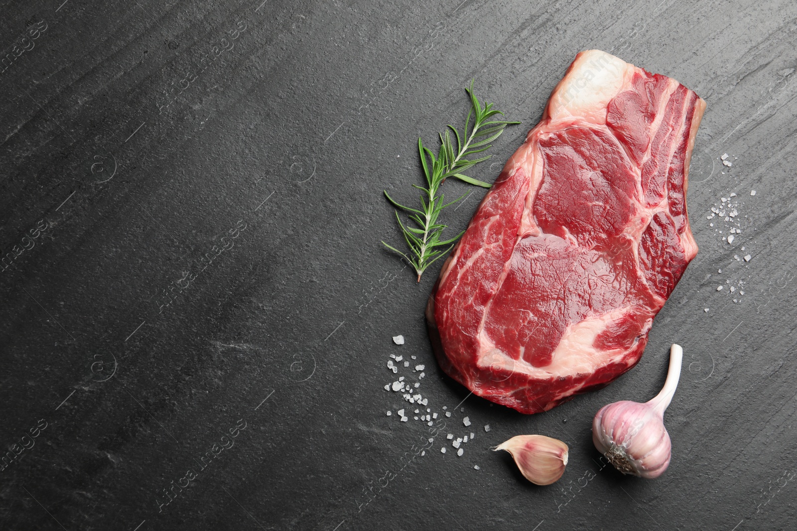 Piece of raw beef meat and spices on black table, flat lay. Space for text Photo of Piece of raw beef meat and spices on black table, flat lay. Space for text