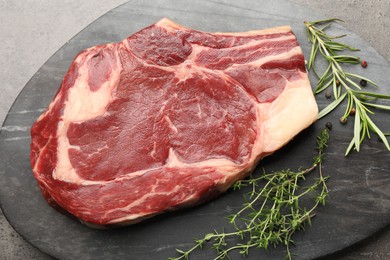 Photo of Piece of raw beef meat and spices on grey table, top view