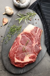 Photo of Piece of raw beef meat and spices on grey table, flat lay