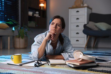 Photo of Worried student preparing for exam on floor at home