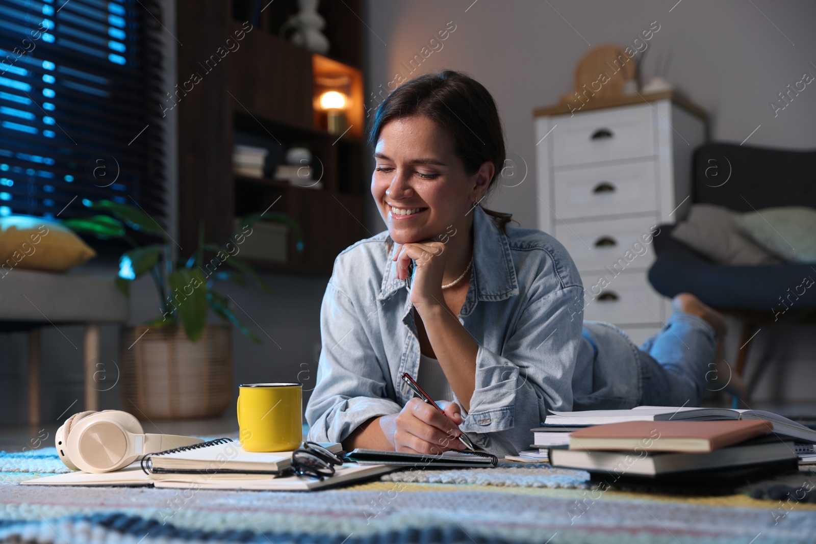 Photo of Happy student preparing for exam on floor at home