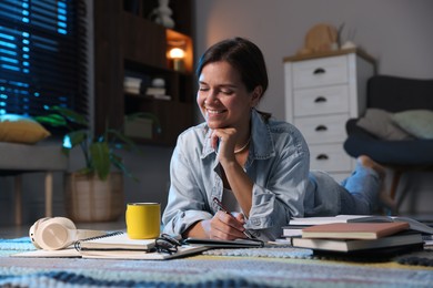 Photo of Happy student preparing for exam on floor at home