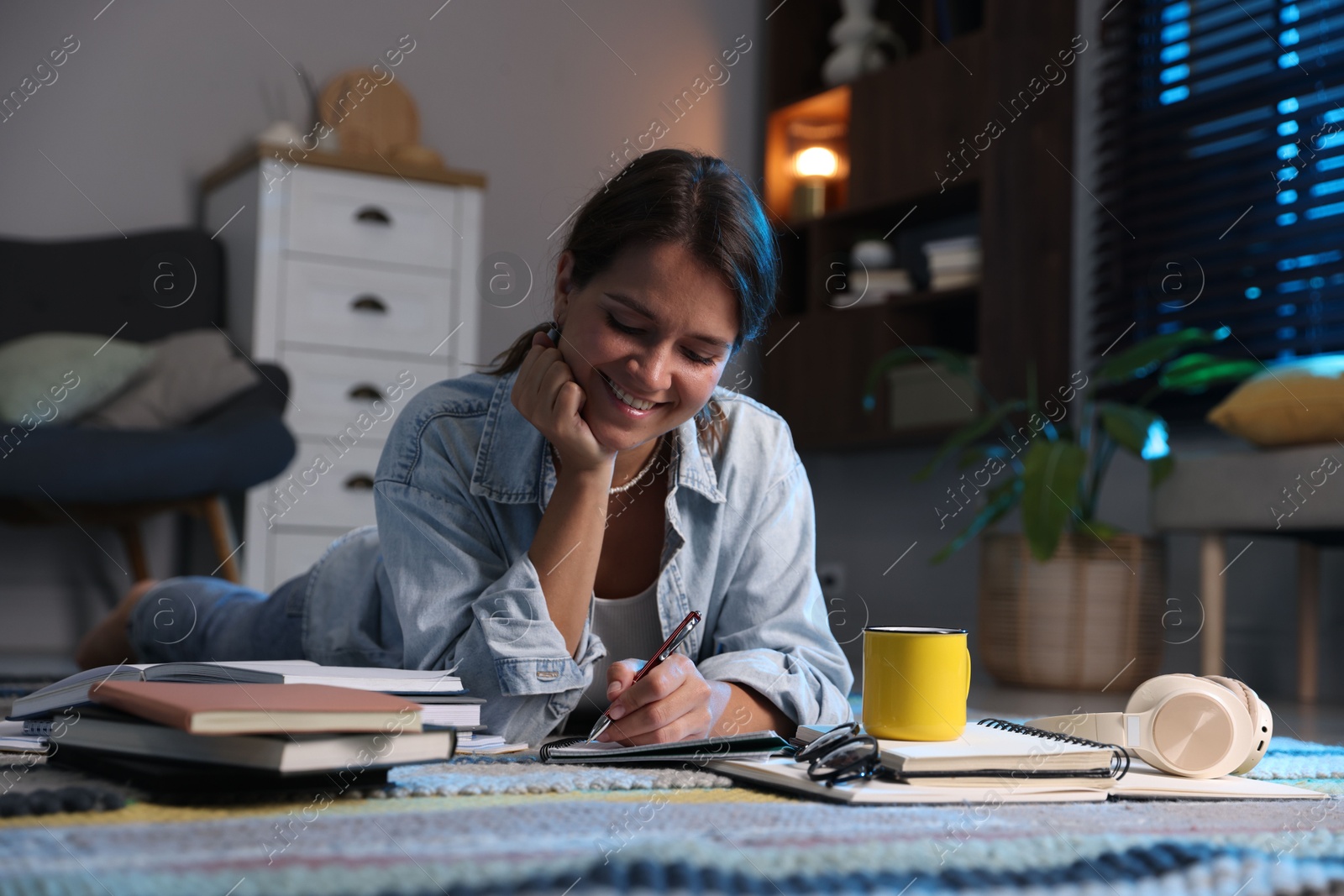 Photo of Happy student preparing for exam on floor at home