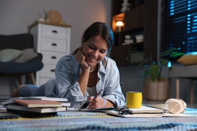 Photo of Happy student preparing for exam on floor at home