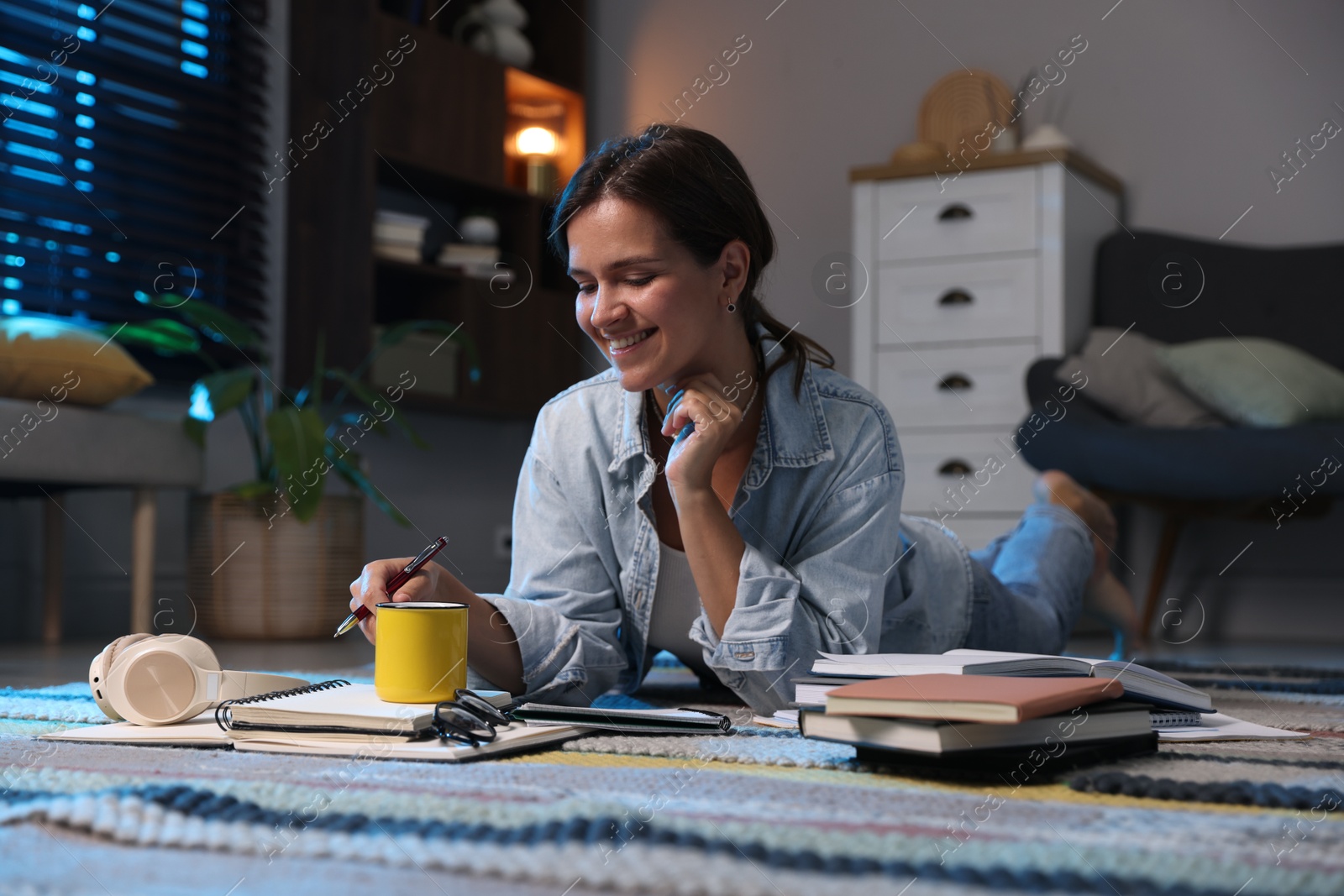 Photo of Happy student preparing for exam on floor at home