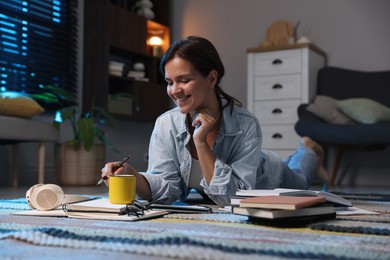 Photo of Happy student preparing for exam on floor at home
