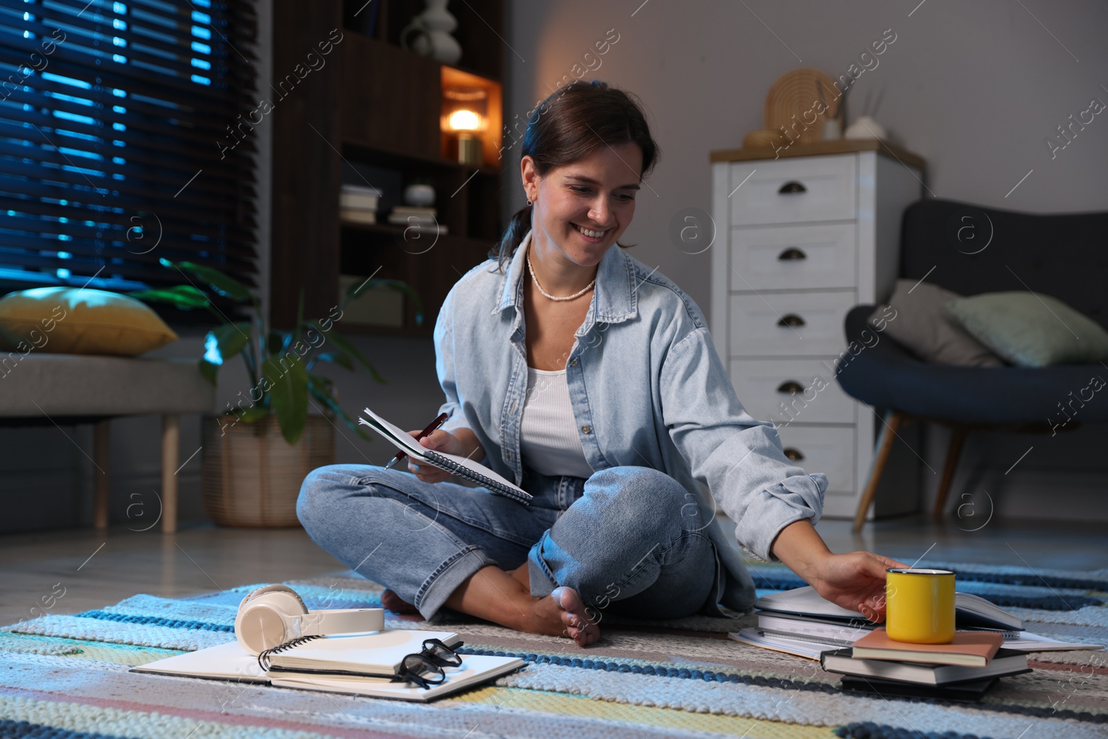 Photo of Happy student preparing for exam on floor at home
