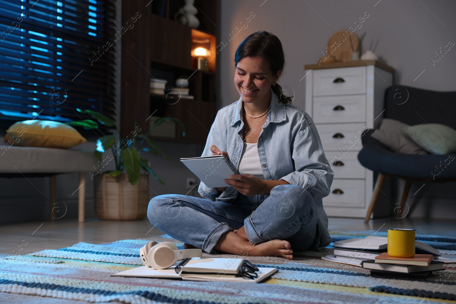 Photo of Happy student preparing for exam on floor at home
