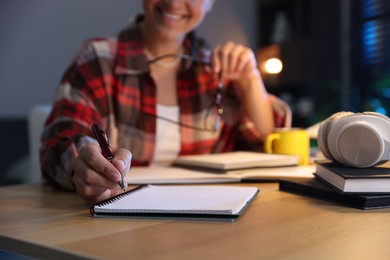 Photo of Student preparing for exam at wooden desk indoors, closeup