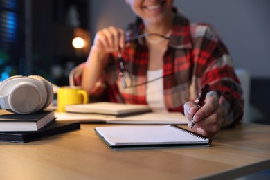 Photo of Student preparing for exam at wooden desk indoors, closeup