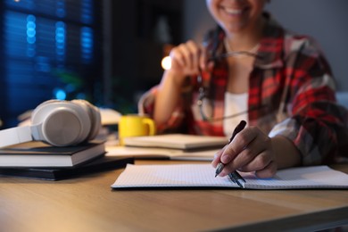 Photo of Student preparing for exam at wooden desk indoors, closeup