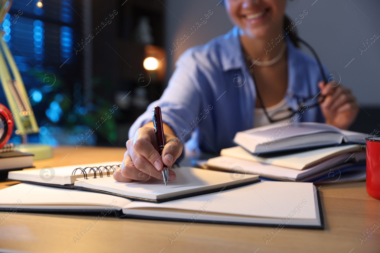 Photo of Student preparing for exam at wooden desk indoors, closeup