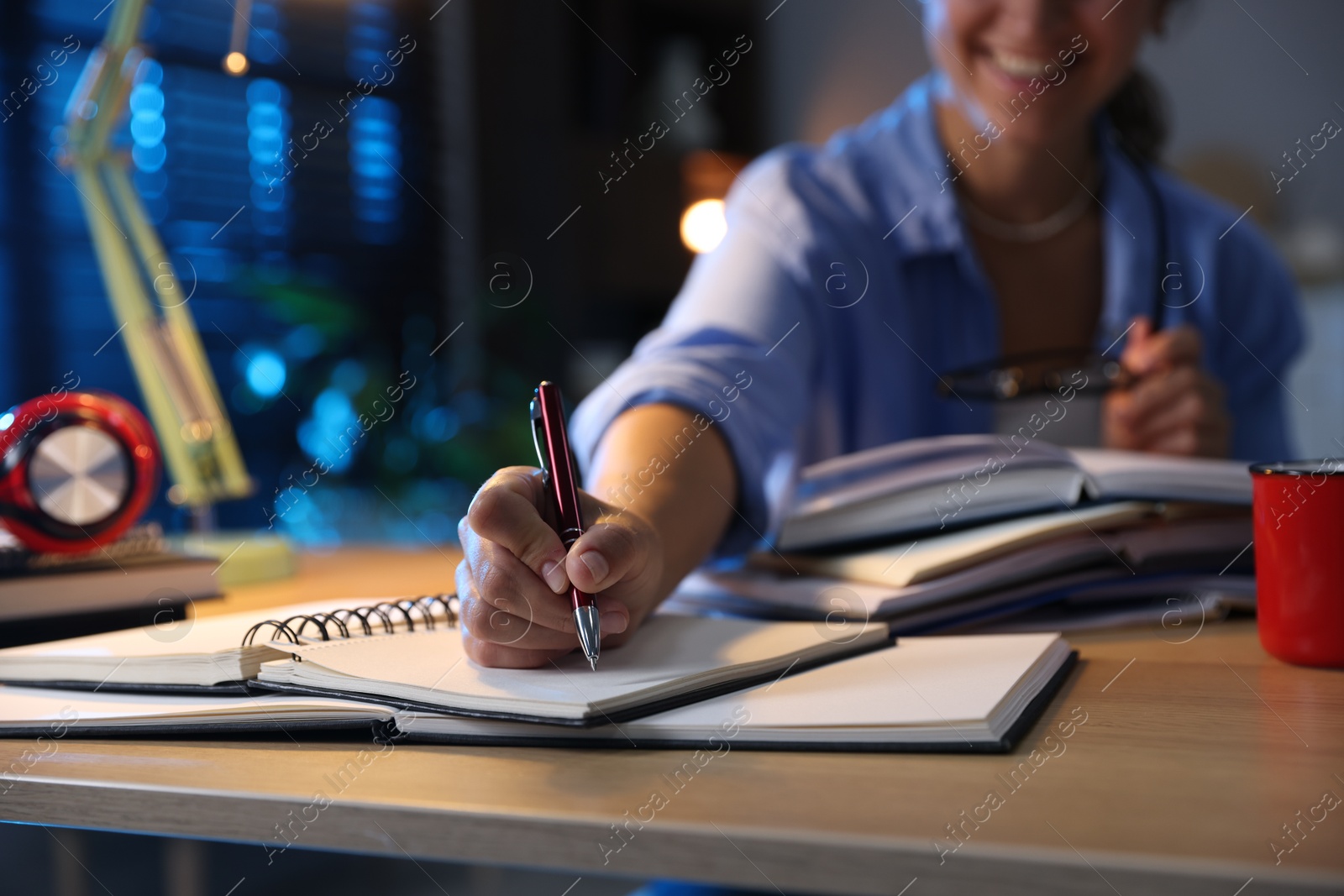 Photo of Student preparing for exam at wooden desk indoors, closeup