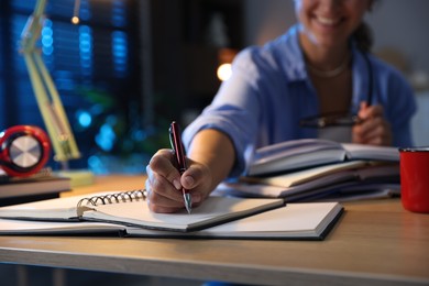 Photo of Student preparing for exam at wooden desk indoors, closeup