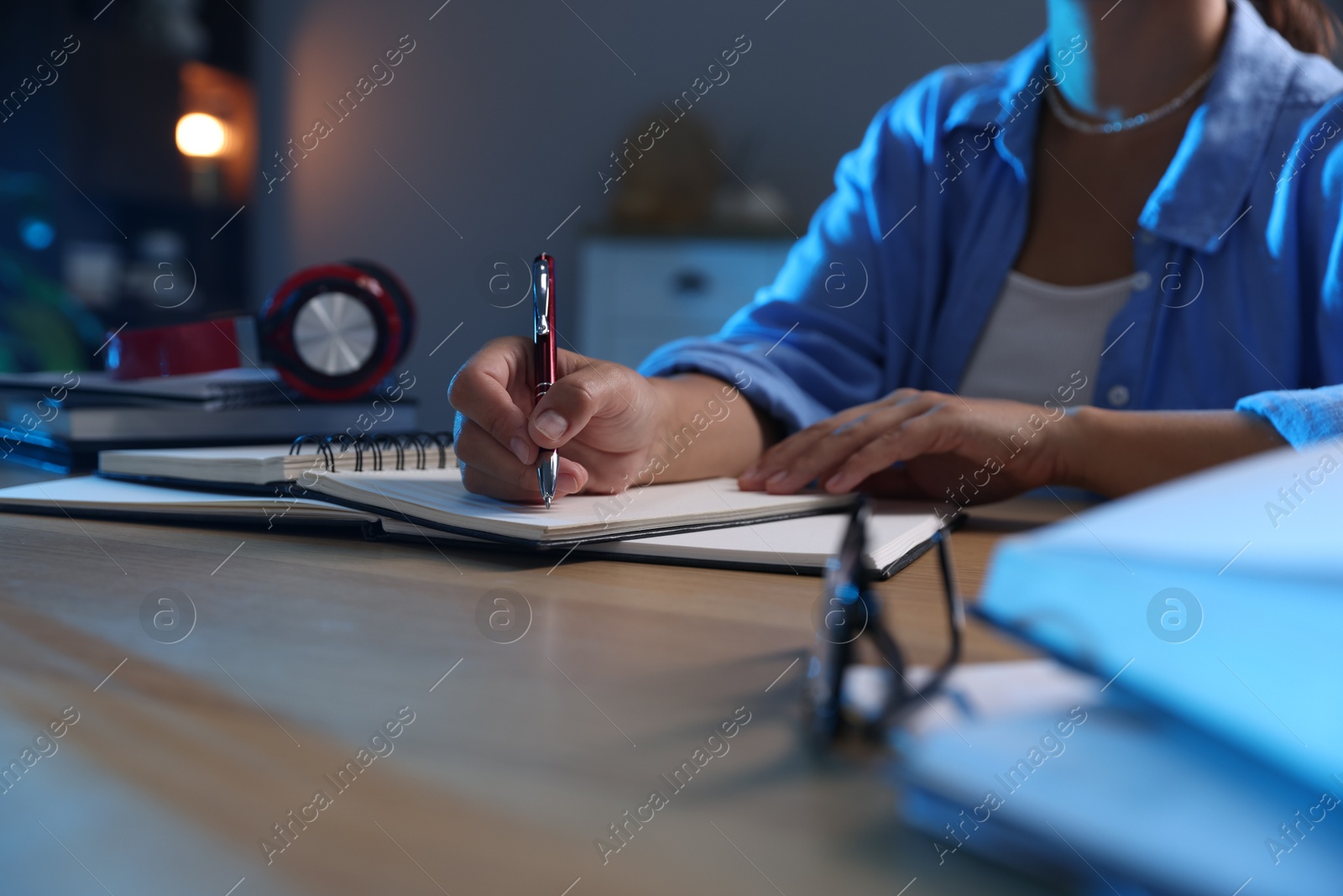 Photo of Student preparing for exam at wooden desk indoors, closeup