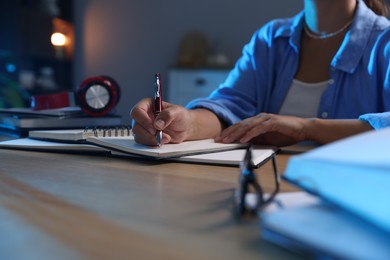 Photo of Student preparing for exam at wooden desk indoors, closeup