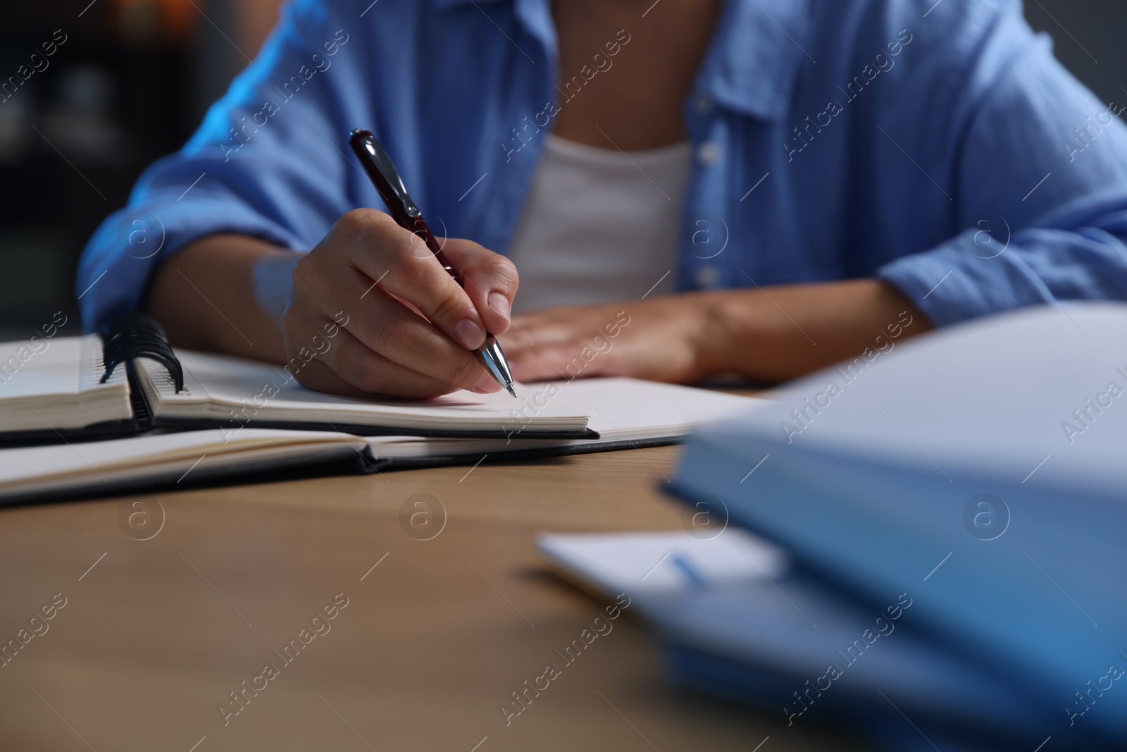 Photo of Student preparing for exam at wooden desk indoors, closeup