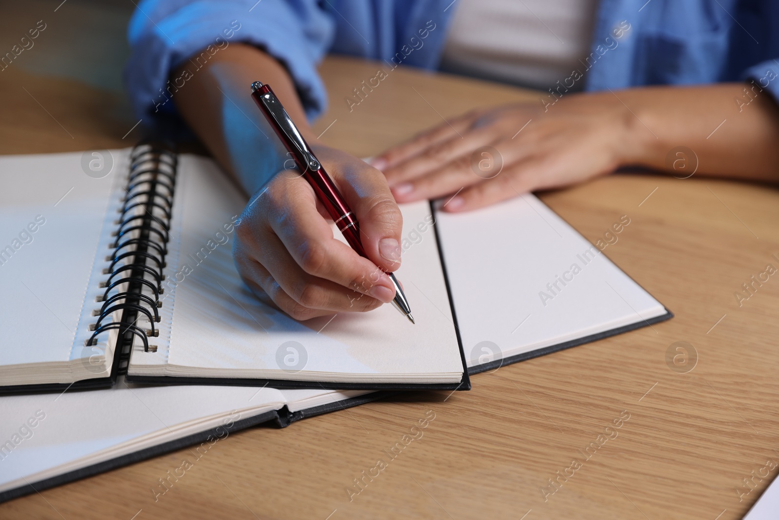 Photo of Student preparing for exam at wooden desk indoors, closeup