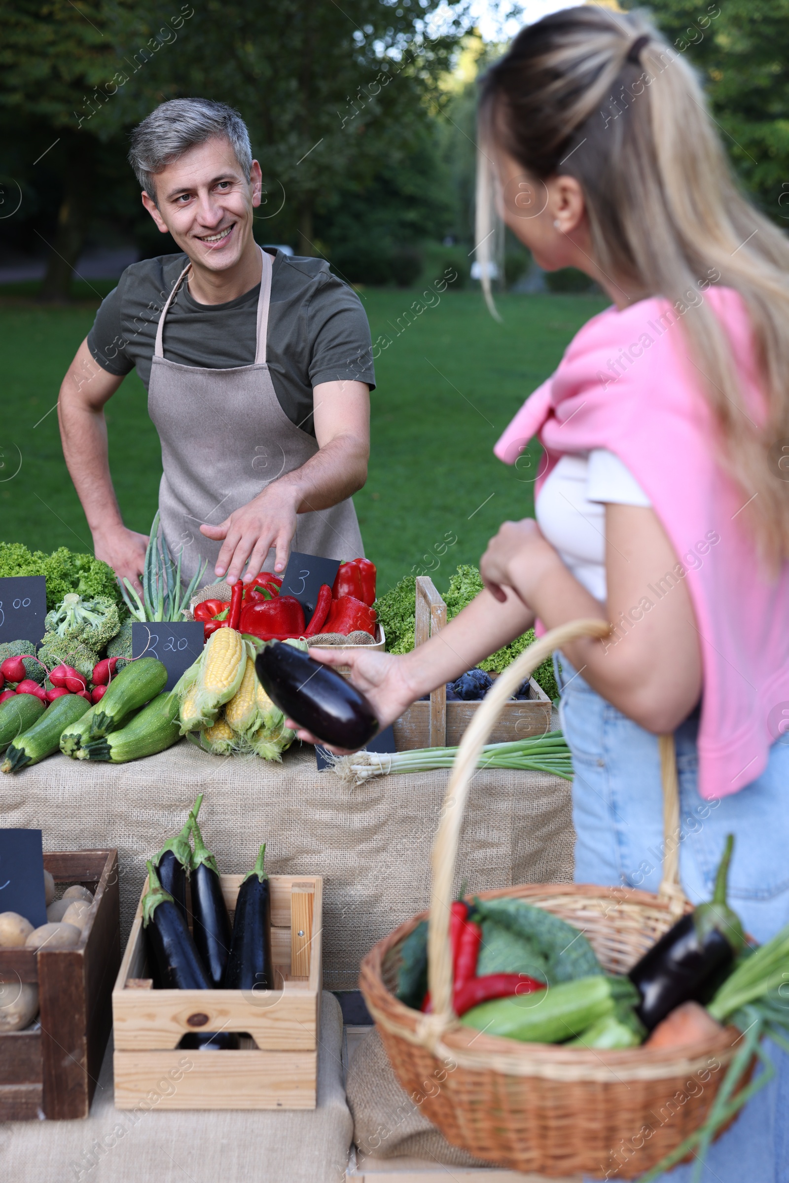 Photo of Woman choosing fresh vegetables from stall at farmer's market
