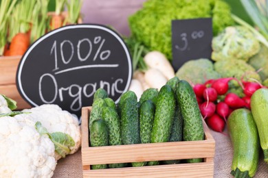 Photo of Many different vegetables and 100% Organic sign on stall at farmer's market, closeup