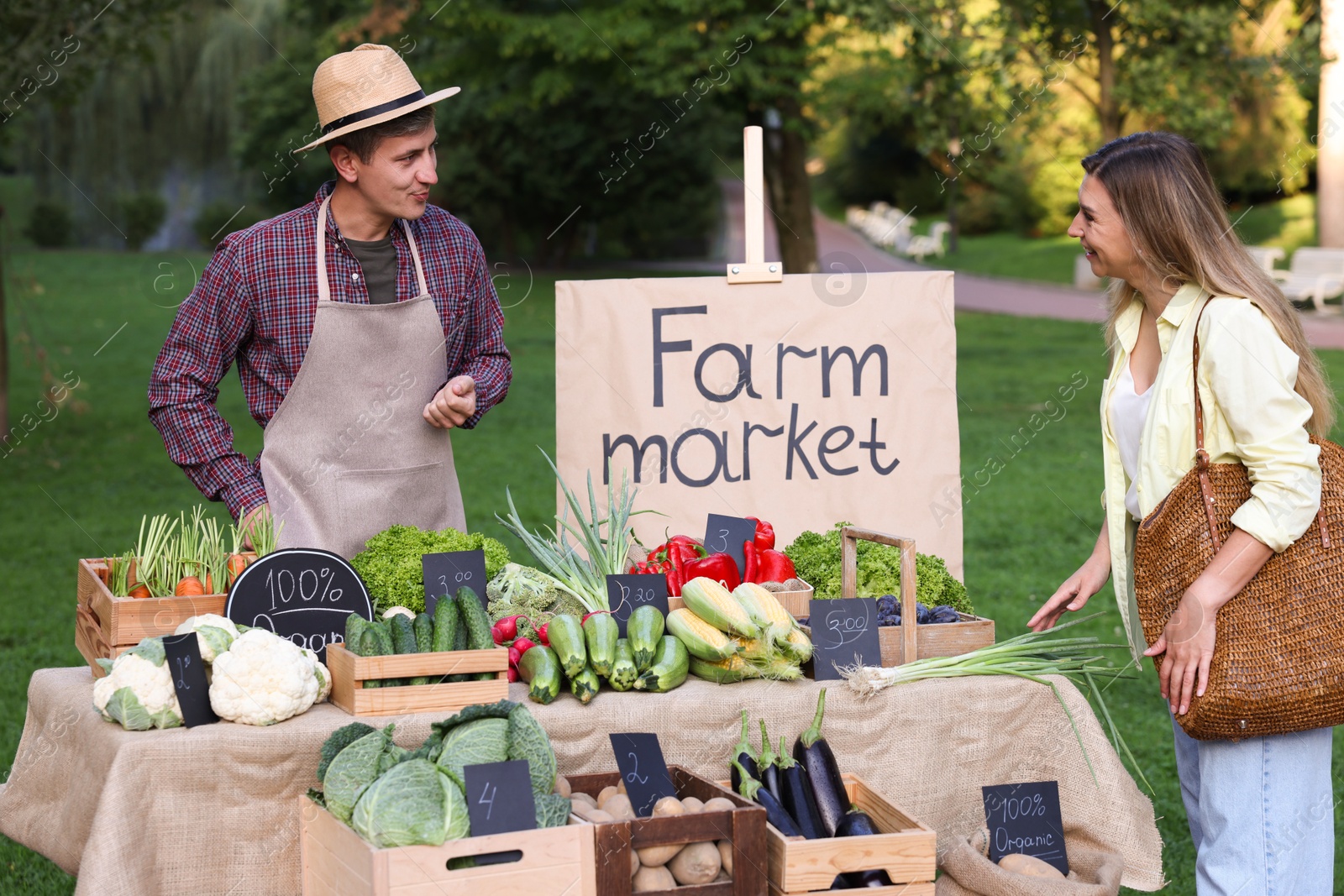 Photo of Woman choosing fresh vegetables from stall at farmer's market
