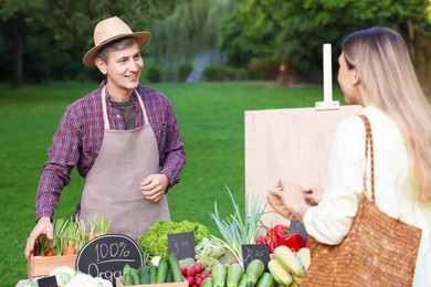 Photo of Woman choosing fresh vegetables from stall at farmer's market