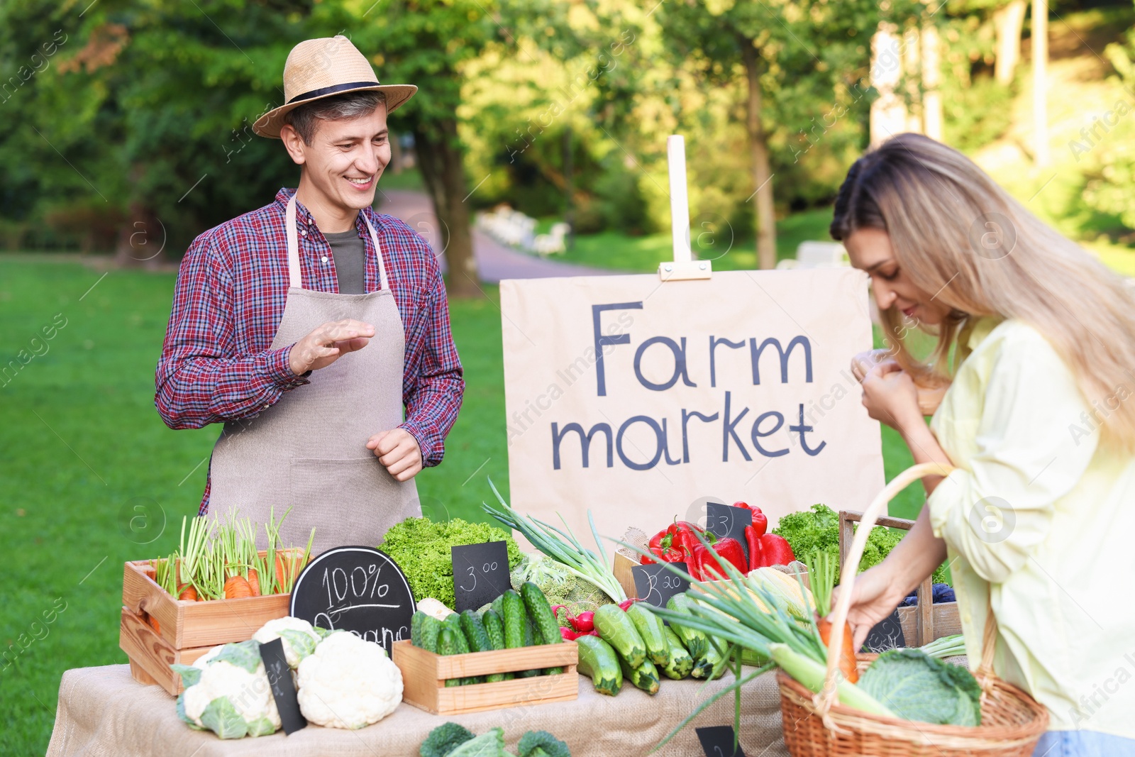 Photo of Woman choosing fresh vegetables from stall at farmer's market