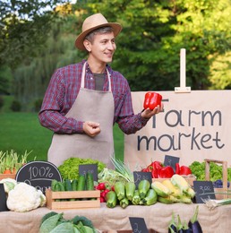 Photo of Woman choosing fresh vegetables from stall at farmer's market