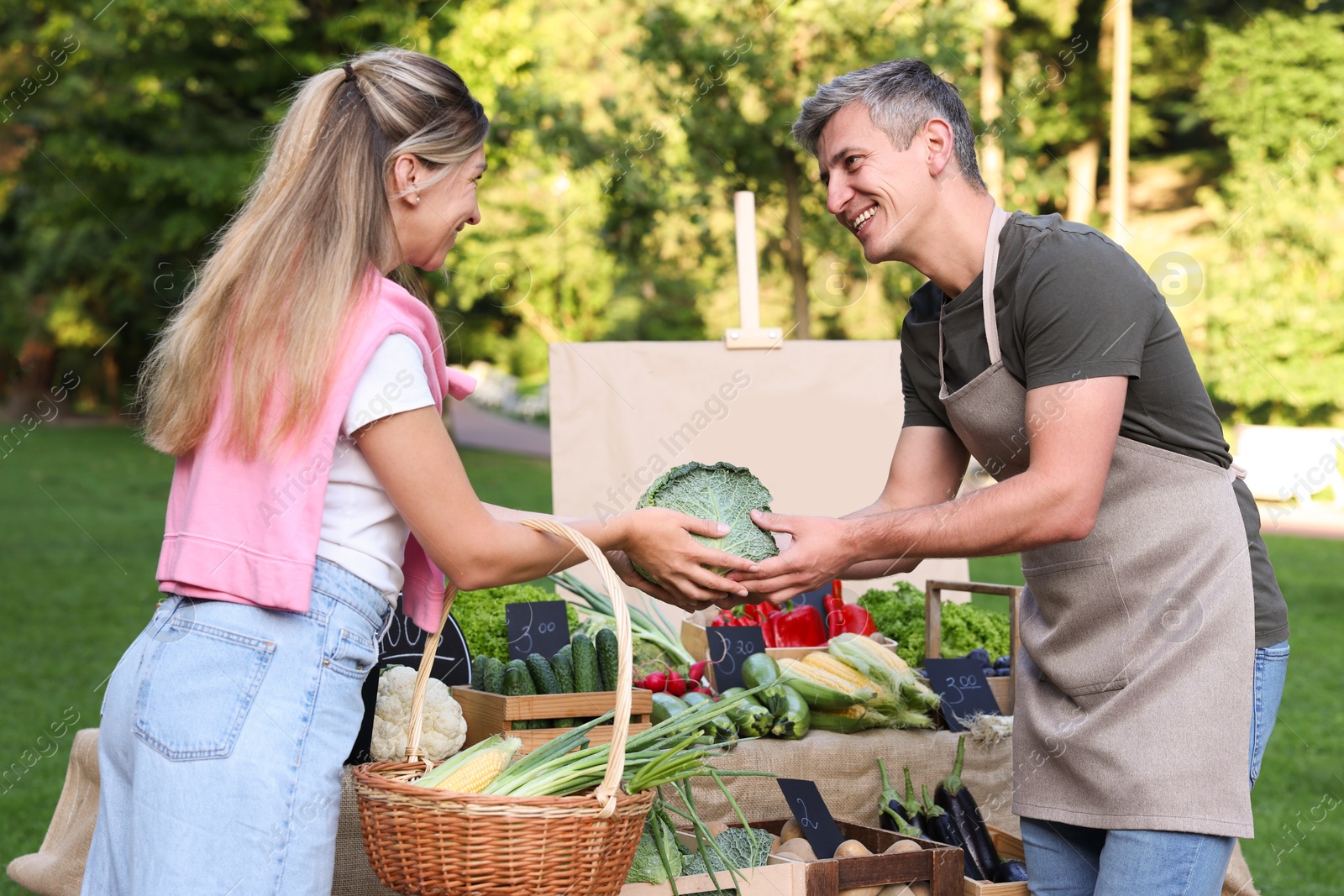 Photo of Woman choosing fresh vegetables from stall at farmer's market
