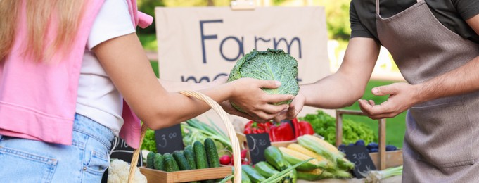 Photo of Woman choosing fresh vegetables from stall at farmer's market, closeup