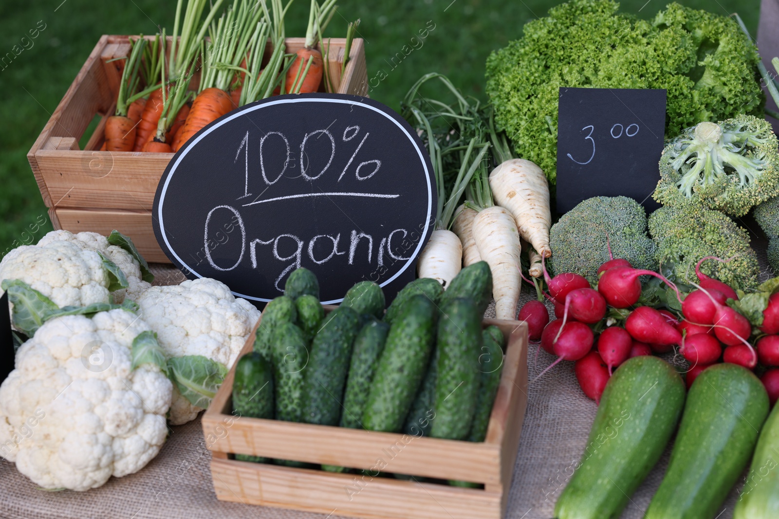 Photo of Many different vegetables and 100% Organic sign on stall at farmer's market